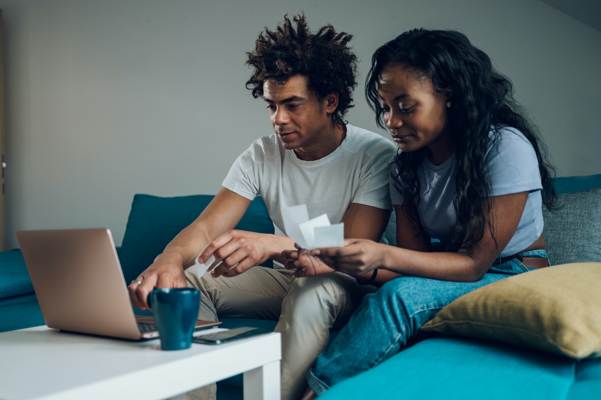 African american couple using a laptop and a credit card while doing finances